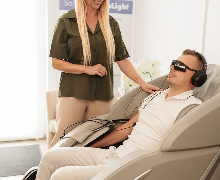 Michaela Schön demonstriert einem Klienten die Bedienung eines Wellness-Geräts